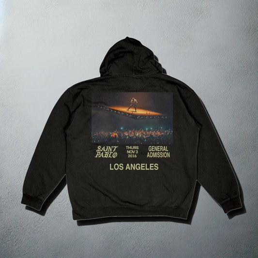 Black 'Saint Pablo' tour hoodie with event details and concert image on the back for Kanye merchandise