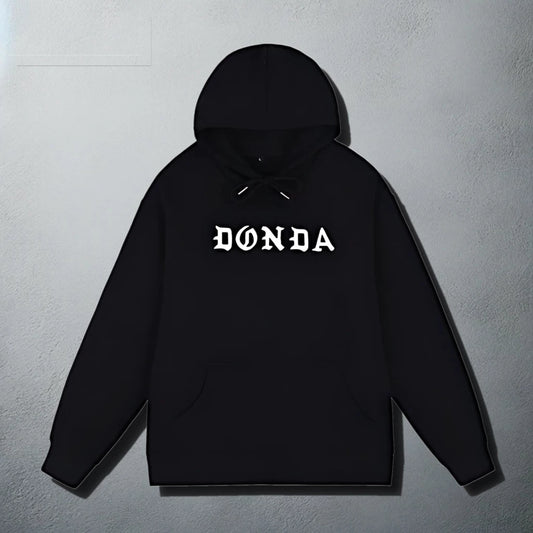 A sleek black hoodie with a white kanye west 'DONDA' text graphic across the chest. The hoodie features a front pouch pocket and an adjustable drawstring hood, designed in a classic pull-over style.