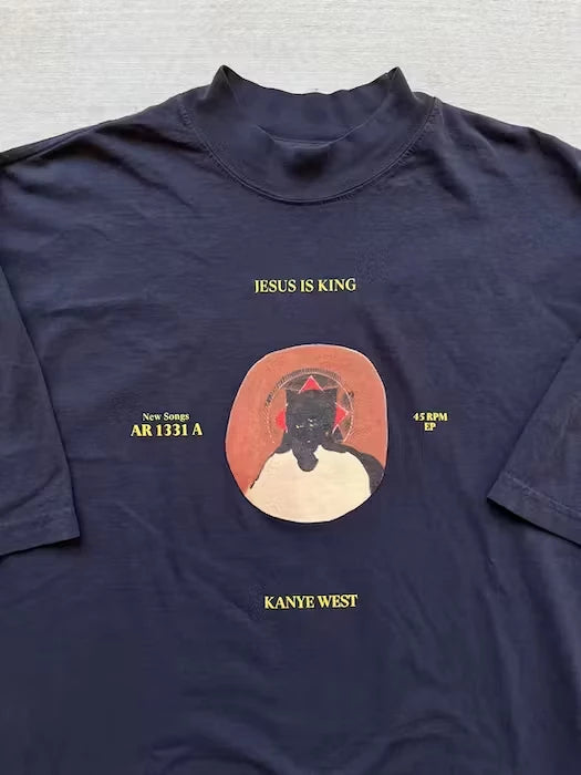 Navy blue t-shirt featuring the 'Jesus is King' album art with vinyl record design, showcasing Kanye West's iconic bear mascot in a crown, emphasizing the album's gospel influence.