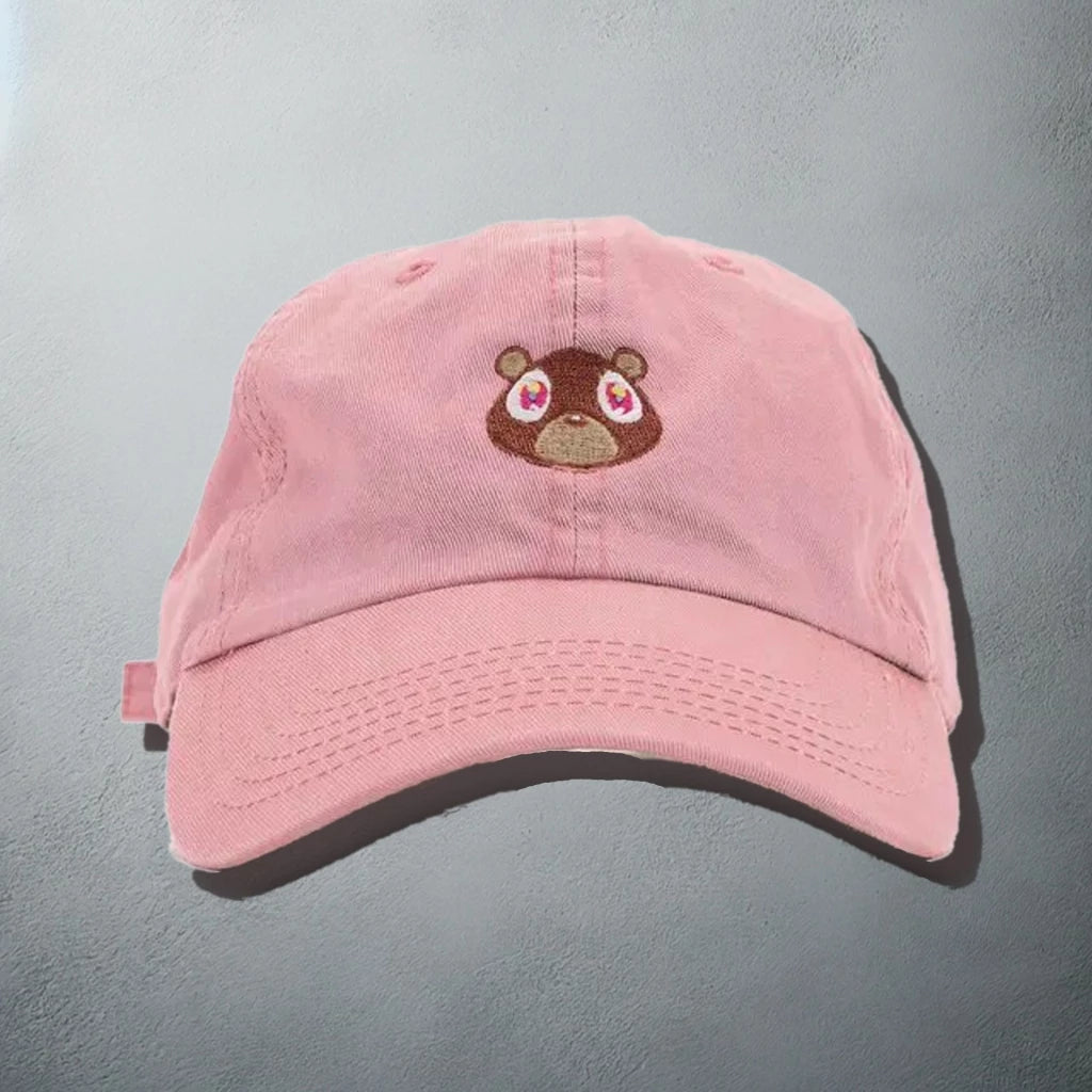 Pastel pink baseball cap with an embroidered bear face, inspired by Kanye West's 'Graduation' album artwork