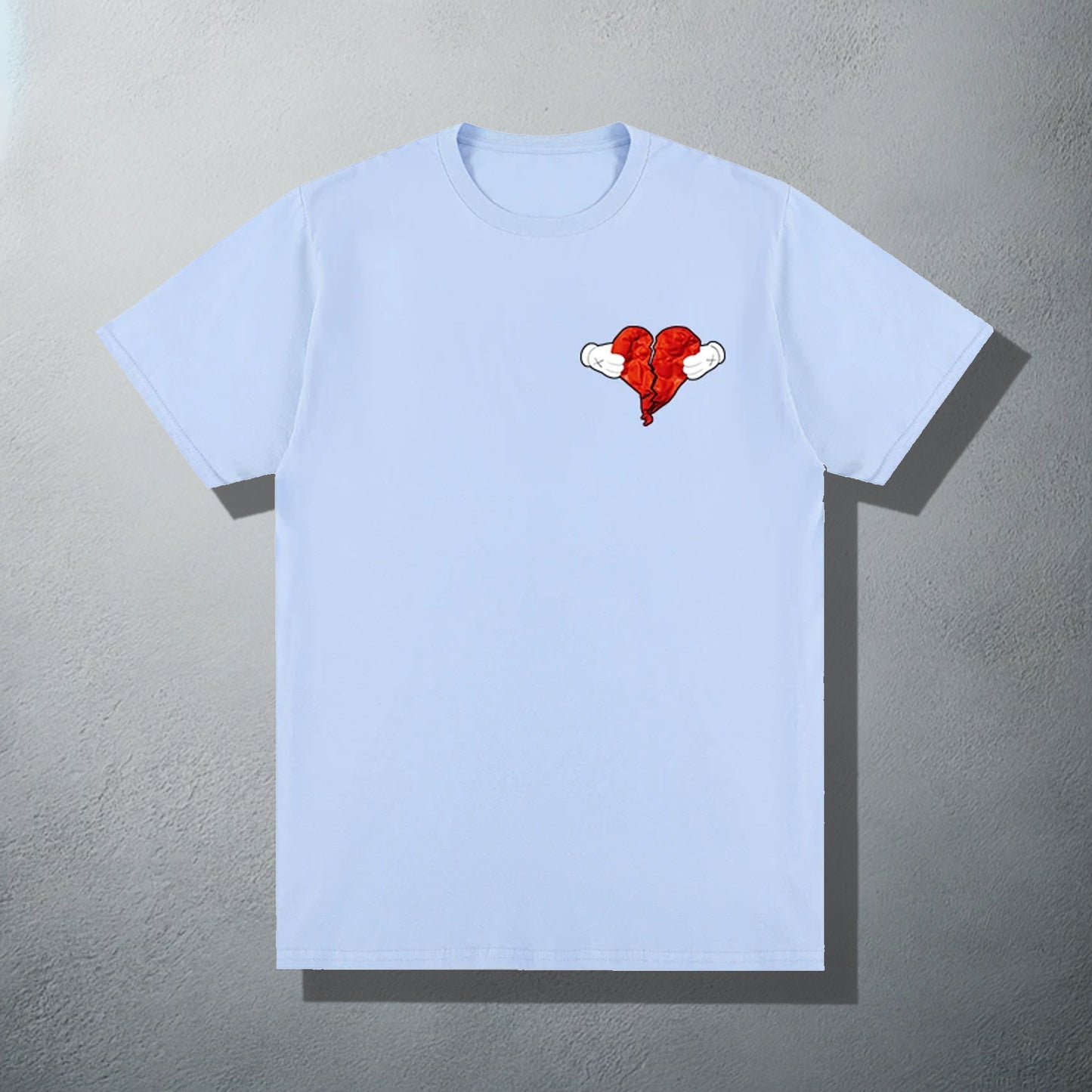 Blue T-shirt featuring a 'Heartless' inspired red heart with wings graphic, referencing Kanye's '808s & Heartbreak' album