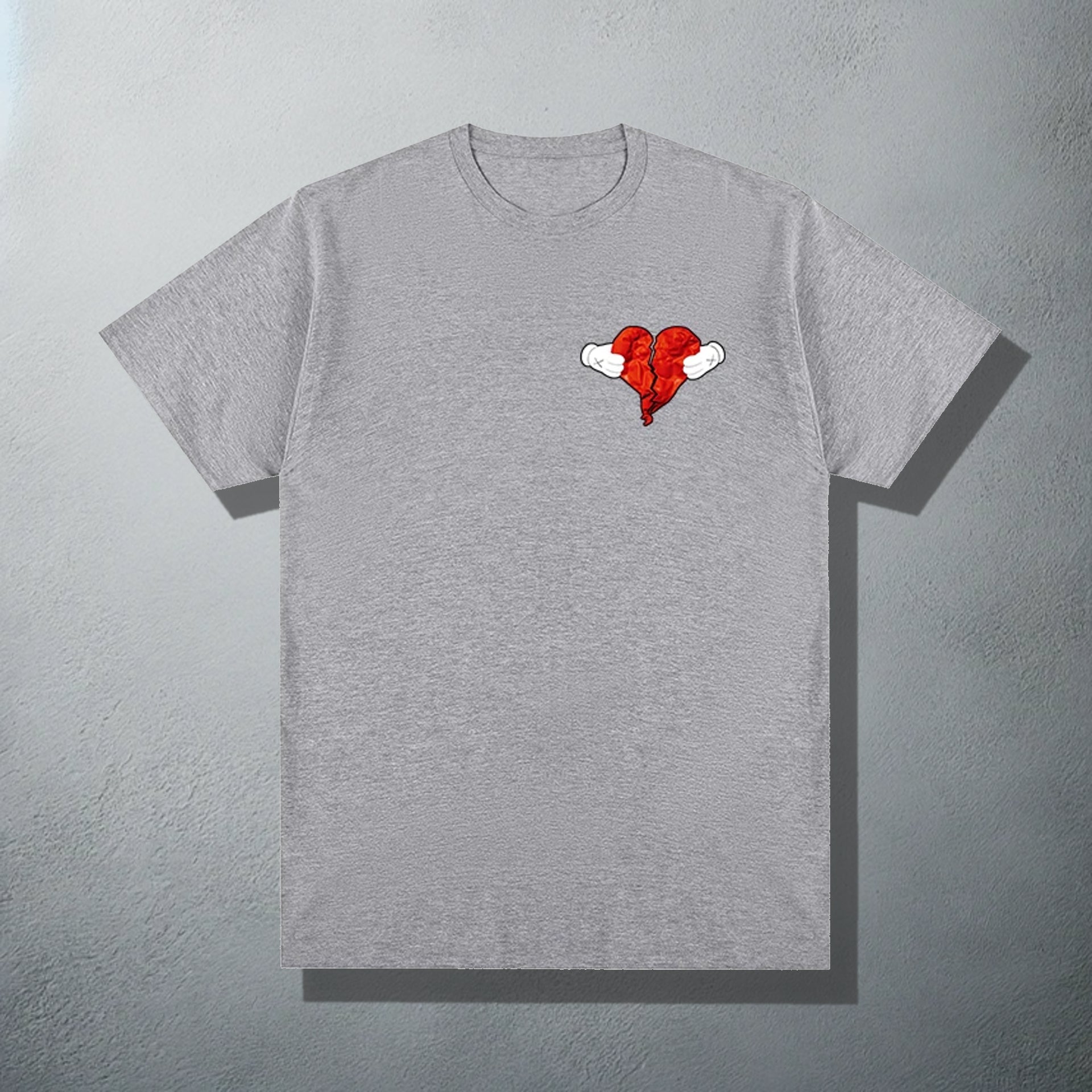 Grey T-shirt featuring a 'Heartless' inspired red heart with wings graphic, referencing Kanye's '808s & Heartbreak' album