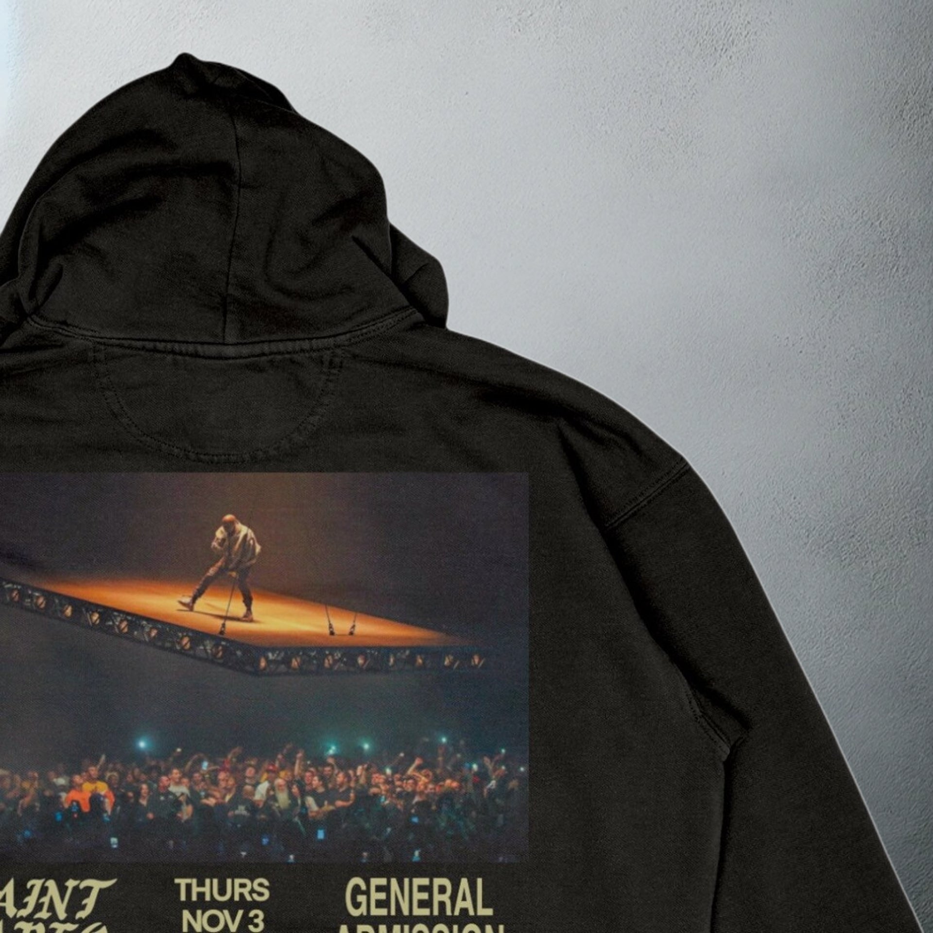 Close up of the Black 'Saint Pablo' tour hoodie with event details and concert image on the back, for Kanye merchandise